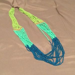 Multi strand tri-color seed bead necklace with gold accent.